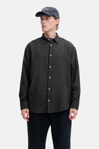 Zwart, lange mouwen hemd van CORE BY JACK & JONES, met een ruitpatroon, witte knopen en een donkere pet.
