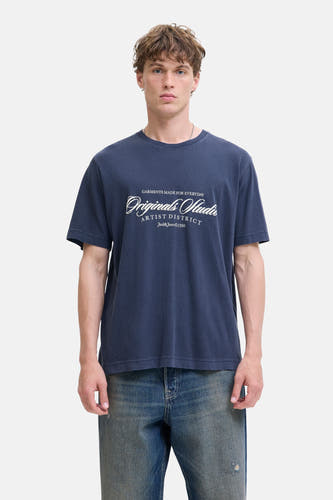 T-shirt bleu à manches courtes d'ORIGINALS par JACK & JONES, avec une impression de texte blanche, porté avec un jean bleu.
