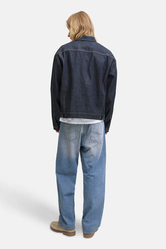 Jean large mi-bleu denim de JACK & JONES JEANS INTELLIGENCE, porté avec un blouson denim et des chaussures beige, vue arrière.