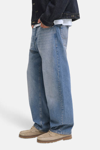 Jean décontracté en denim bleu de JACK & JONES JEANS INTELLIGENCE, avec une coupe ample et des chaussures marrons.