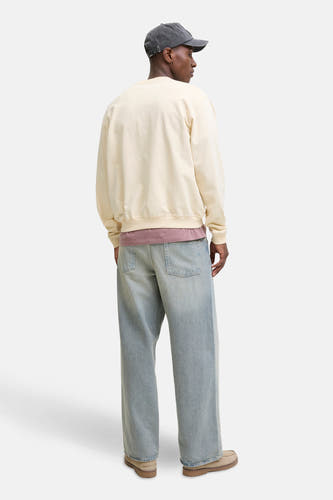 Beige sweater van ORIGINALS BY JACK & JONES, met lange mouwen en ronde hals, gedragen met een pet en wijde jeans.
