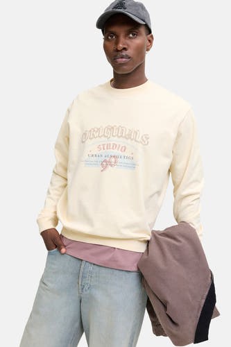 Beige sweater van ORIGINALS BY JACK & JONES, met een vintage print op de voorkant, gedragen met een pet en jeans.
