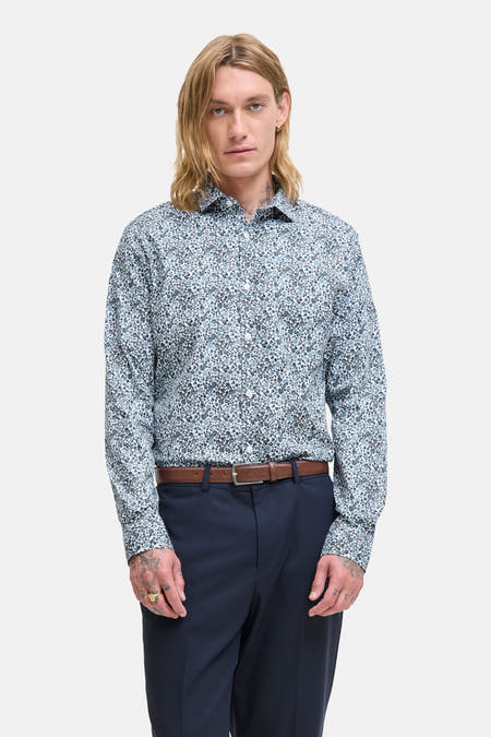 Blauw overhemd met lange mouwen van PREMIUM by JACK & JONES, met bloemenprint, gecombineerd met een bruine riem en donkerblauwe pantalon.