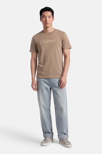 Bruin T-shirt met korte mouwen van ORIGINALS BY JACK & JONES, met een tekstprint op de borst, gecombineerd met jeans en sneakers.
