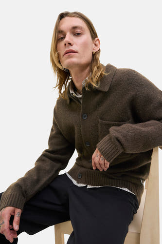 Bruin gilet van PREMIUM BLUE by JACK & JONES, met knoopsluiting en een borstzak, gedragen over een gestreept overhemd en zwarte broek.
