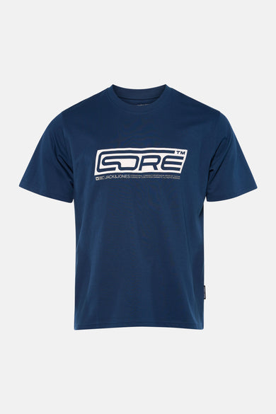 T-shirt bleu à manches courtes de CORE BY JACK & JONES, vu par derrière, porté avec des jeans légers et des chaussures blanches.