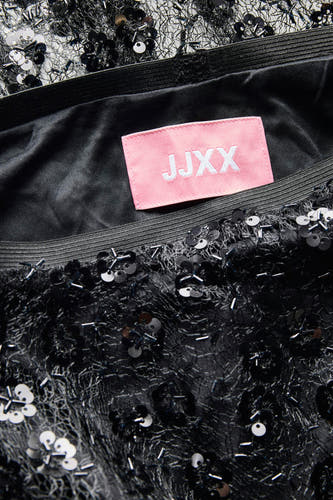Zwarte lange rok van JJXX, met lovertjes en kralen versierd, close-up shot.
