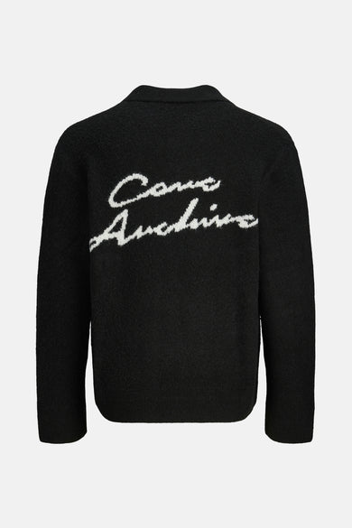 Sweat-shirt noir à col V de CORE BY JACK & JONES, avec une texture tricotée et un texte blanc sur le dos.