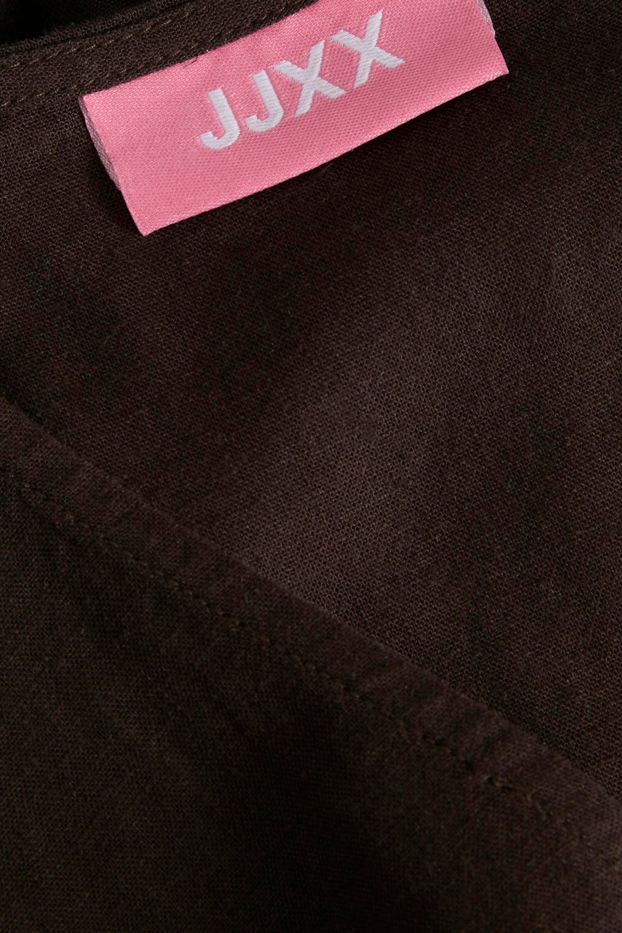 Bruine blouse van JJXX met roze label met witte tekst en zichtbare weefseltextuur.