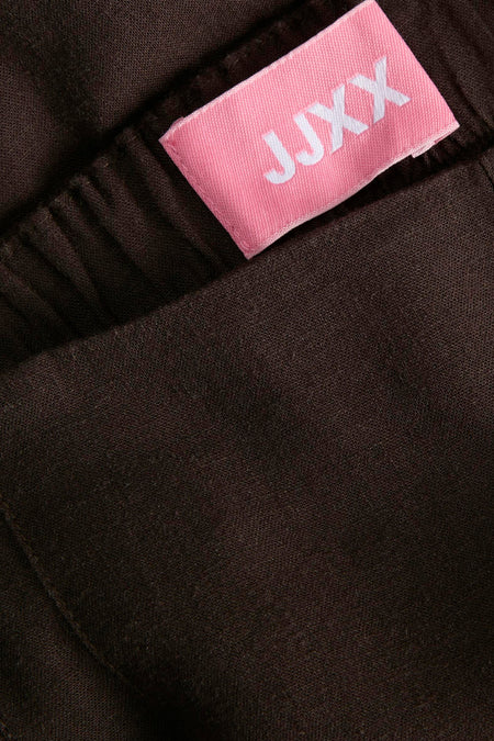 Bruine broek van JJXX, met een effen kleur en textuur, close-up weergave.
