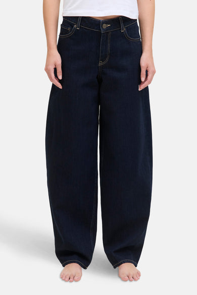 Donkerblauwe denim jeans special fit van JJXX, met gele stiksels en een wijde pijp, op een model.

