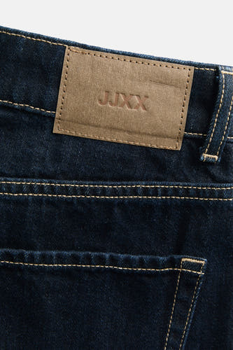 Jean en denim bleu marine de JJXX, avec des rivets et une étiquette en cuir marron sur l'arrière.