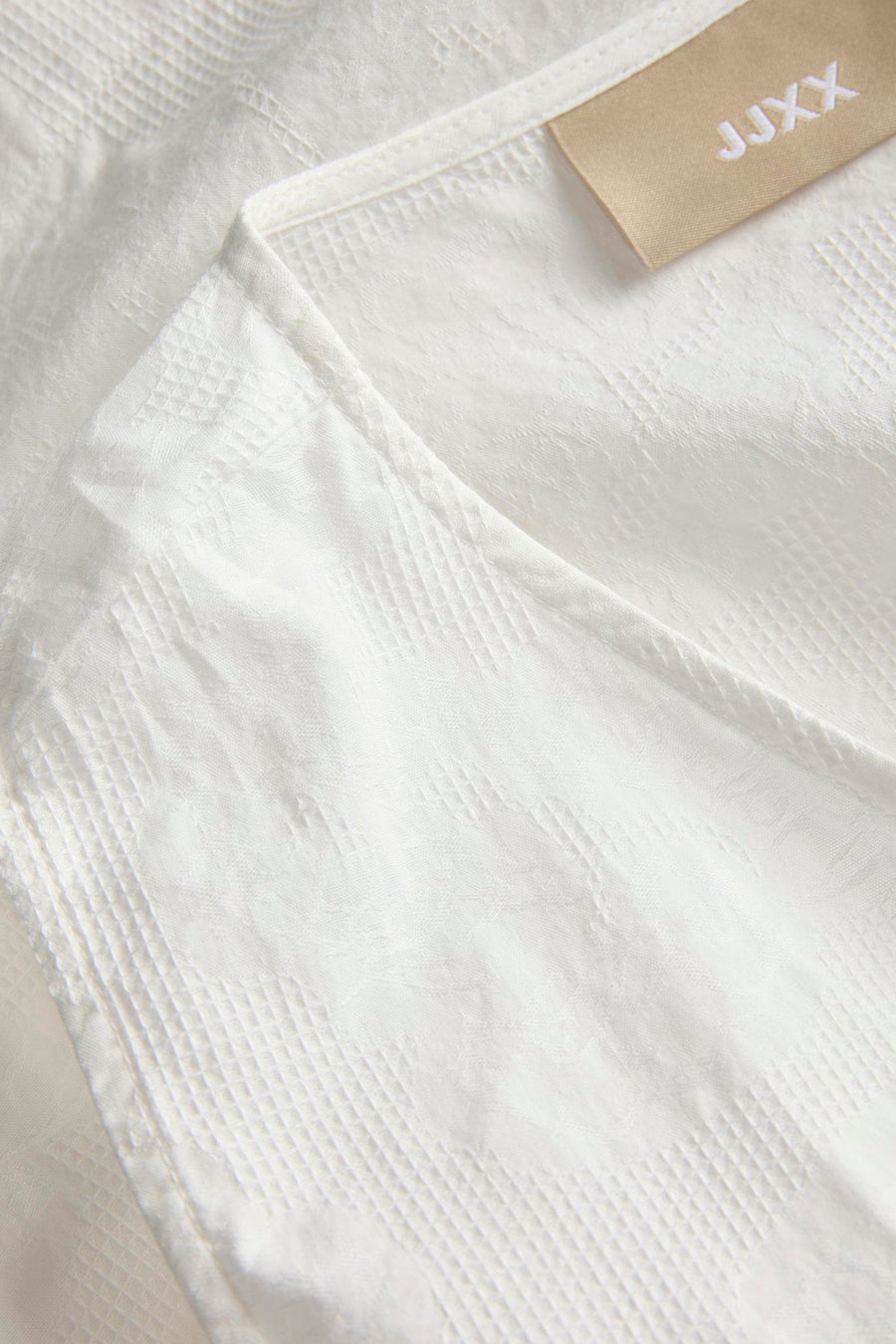 Witte blouse van JJXX met een subtiel ruitjespatroon en detail van de halslijn.
