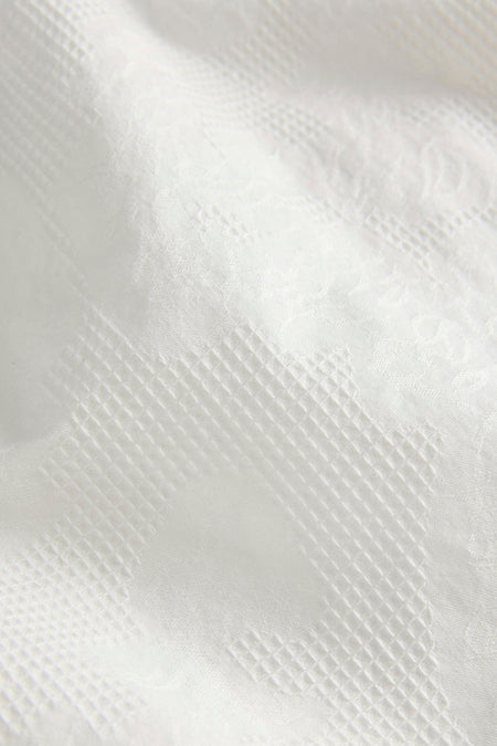 Witte short van JJXX met subtiele ingeweven ruit- en bloemenpatronen.