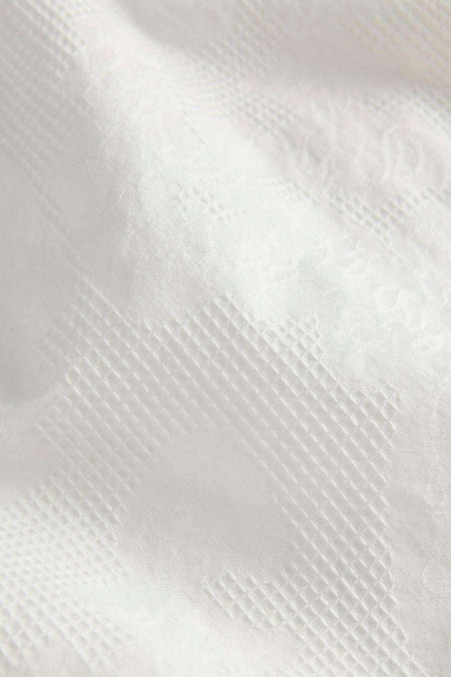 Witte short van JJXX met subtiele ingeweven ruit- en bloemenpatronen.