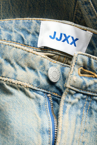 Jean bleu moyen droit de JJXX, avec fermeture éclair et boutons et un étiquette sur la ceinture.