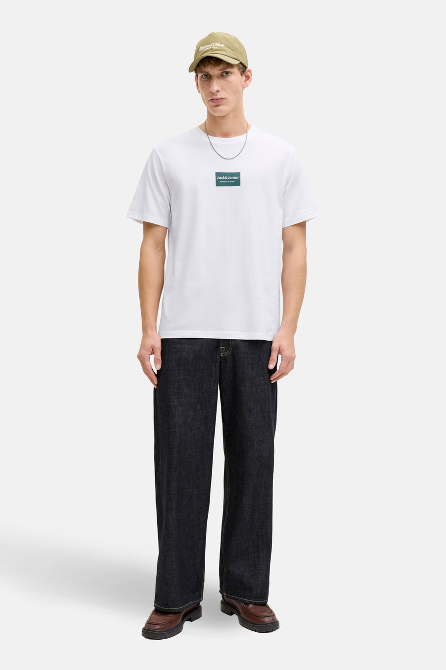 Wit T-shirt met korte mouwen van CORE by JACK & JONES, met logo op de borst, gecombineerd met een pet en donkere jeans.