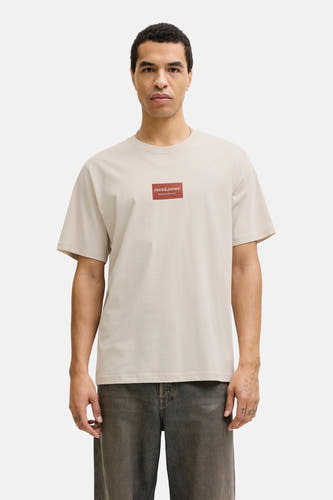 Beige T-shirt met korte mouwen van CORE BY JACK & JONES, met een rood logo-embleem op de borst.