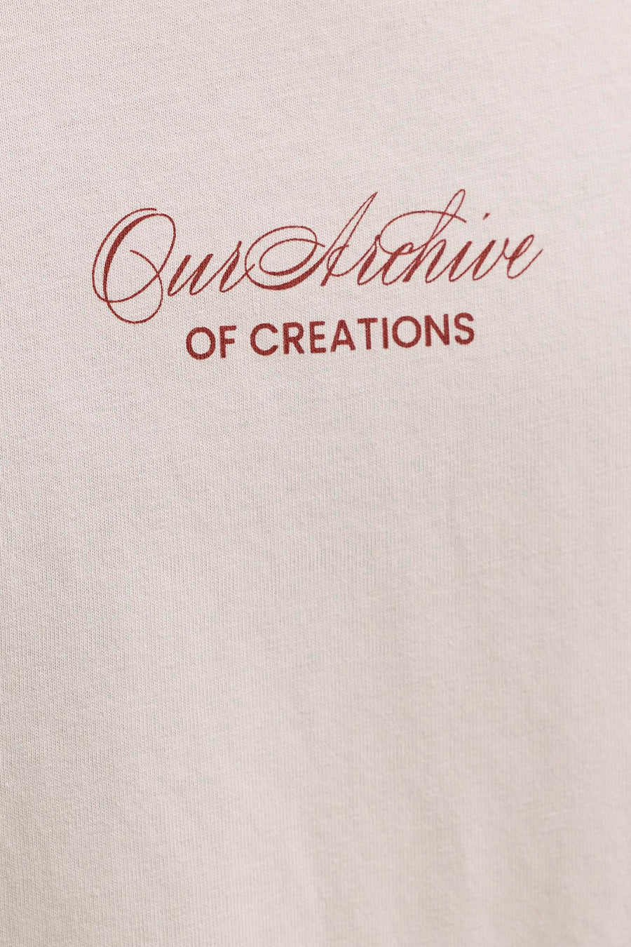 Beige T-shirt van ORIGINALS BY JACK & JONES met rode scripttekst 'Our Archive OF CREATIONS' op een gebreide stof.
