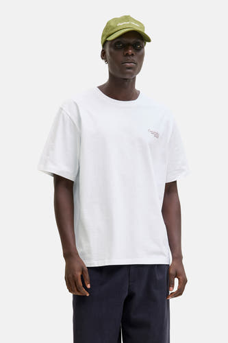 Wit T-shirt met korte mouwen van ORIGINALS BY JACK & JONES, met klein opschrift, gedragen met donkere broek en groene pet.