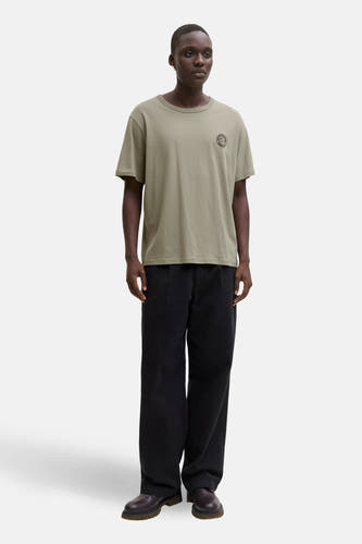 Groen T-shirt met korte mouwen van ORIGINALS BY JACK & JONES, met een logo op de borst, gedragen met zwarte broek en schoenen.
