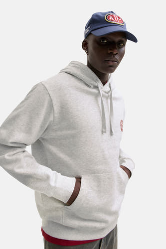 Witte sweater met kap van ORIGINALS BY JACK & JONES, met trekkoorden en buidelzak, gedragen met een pet.
