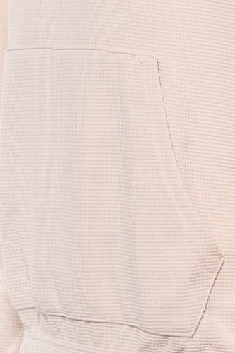 Beige sweater met kap van Core by Jack & Jones, close-up van de kangoeroezak en wafeltextuur.
