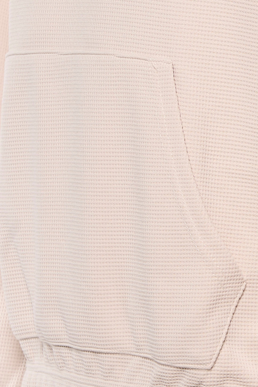 Beige sweater met kap van Core by Jack & Jones, close-up van de kangoeroezak en wafeltextuur.

