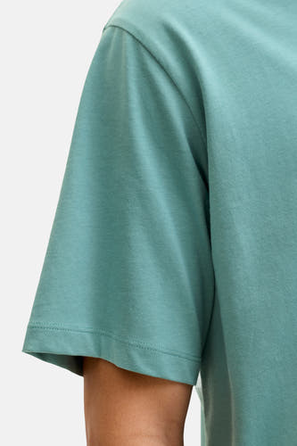 T-shirt bleu à manches courtes de CORE BY JACK & JONES, texture coton douce, partie d'un bras visible.