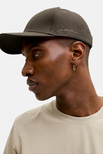 Kaki pet van ACCESSORIES BY JACK & JONES met subtiel geborduurd logo, zijaanzicht op model in beige t-shirt