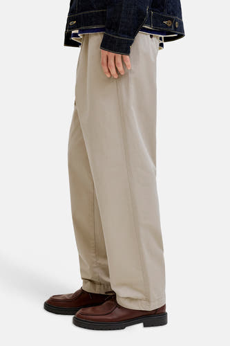 Pantalon beige de JACK & JONES JEANS INTELLIGENCE, avec des jambes larges et des chaussures marrons.