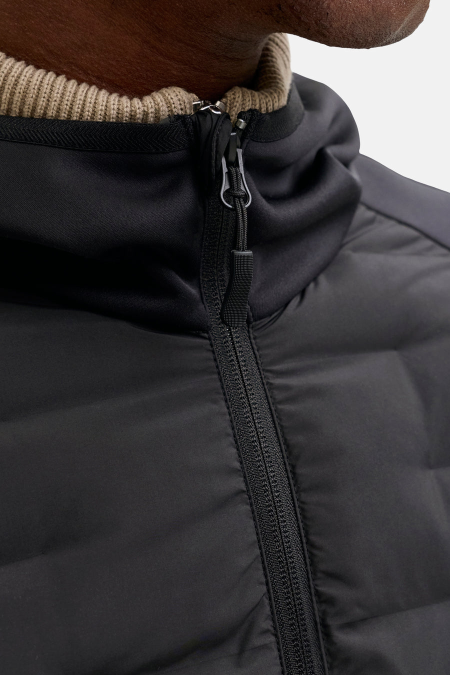 Zwarte gewatteerde jas met ritssluiting.