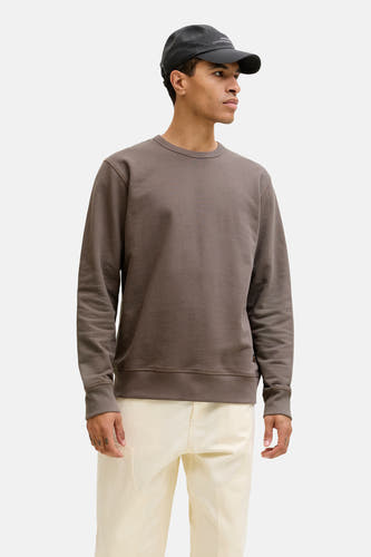 Pull-over marron avec col rond de PREMIUM by JACK & JONES, porté avec des pantalons écru et un chapeau bleu marine.