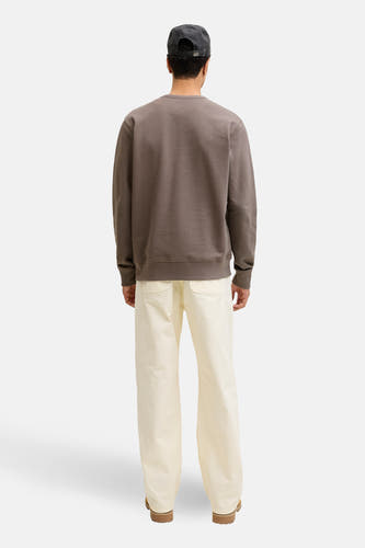 Pull marron avec col rond de PREMIUM by JACK & JONES, vu de dos, avec un pantalon beige et un chapeau.