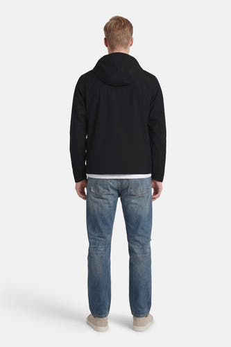 Veste courte noire de CORE BY JACK & JONES, avec capuche, portée avec un jean et des baskets blanches, vue de dos.