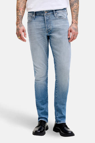 Slim fit jeans van lichtblauw denim van JACK & JONES JEANS INTELLIGENCE, met zwarte schoenen en tatoeages op de armen.
