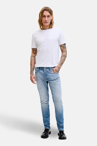Slim jeans van lichtblauw denim van JACK & JONES JEANS INTELLIGENCE, gecombineerd met een wit T-shirt en zwarte schoenen.