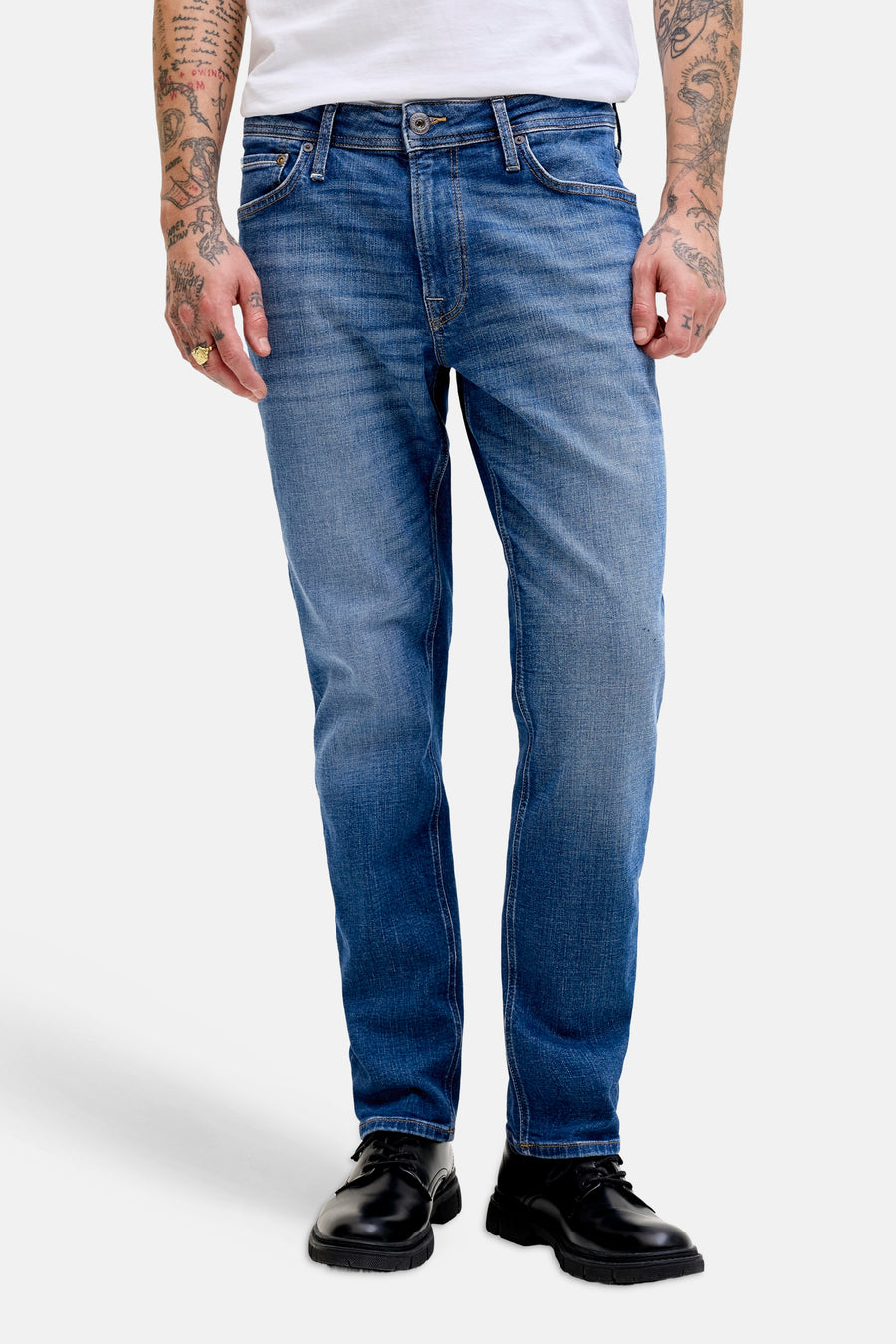 Rechte jeans van middenblauw denim van JACK & JONES JEANS INTELLIGENCE, gedragen door een man met een wit T-shirt en zwarte schoenen.