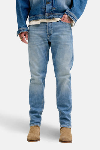 Taps toelopende jeans van denim in middenblauw door JACK & JONES JEANS INTELLIGENCE, met licht verwassen effect en bruine laarzen.