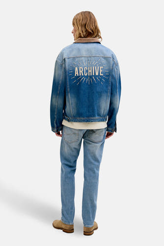 Blauw denim tapered jeans van JACK & JONES JEANS INTELLIGENCE, met licht vervaagde plekken en bruine schoenen.