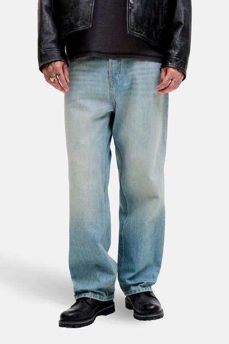 Wijd model jeans van lichtblauw denim door JACK & JONES JEANS INTELLIGENCE, met een ontspannen pasvorm en zwarte schoenen.
