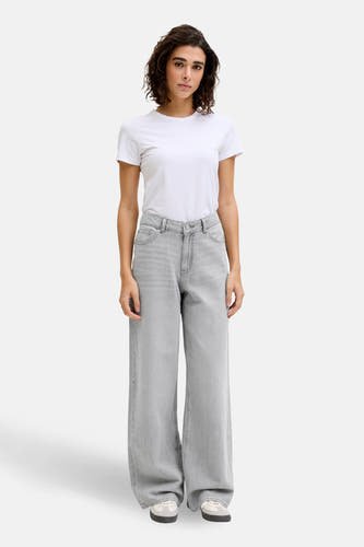 Grijze denim wide jeans van JJXX, gecombineerd met een wit T-shirt en sneakers.