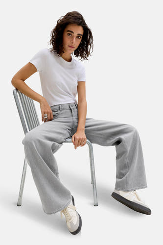 Grijze wijde jeans van JJXX, gedragen met een wit T-shirt en crèmekleurige sneakers.
