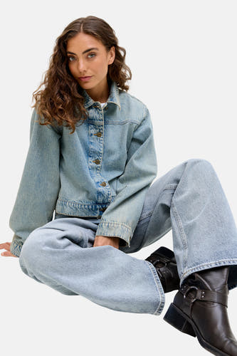 Lichtblauwe denim jeans wide van JJXX, gedragen met een denim jack en leren laarzen.
