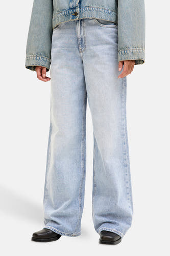 Lichtblauwe denim jeans wide van JJXX, met wijde pijpen en gedragen met een denim jas.
