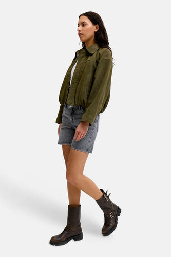 Donkergrijze denim short van JJXX, gedragen door een model met een olijfgroen bomberjack en bruine bikerboots.