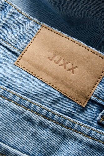Short en jean bleu moyen court de JJXX, avec détail d'étiquette en cuir marron.