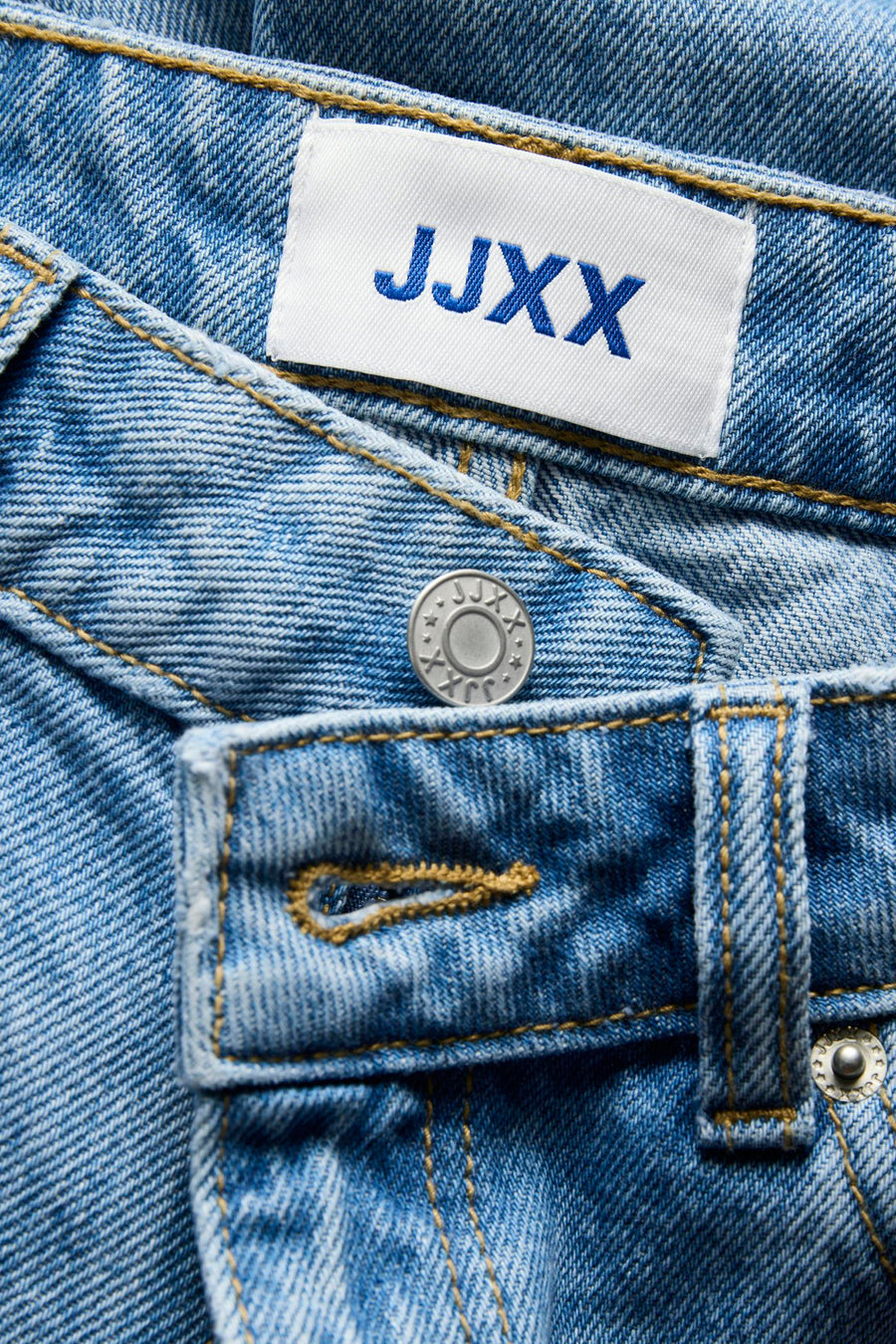 Short en jean bleu moyen de JJXX, avec logo de la marque sur l'étiquette et fermeture à boutons, en gros plan.