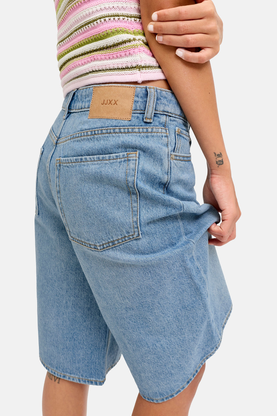 Short en denim bleu moyen de JJXX, avec poche arrière et étiquette de marque, combiné avec un haut rayé.
