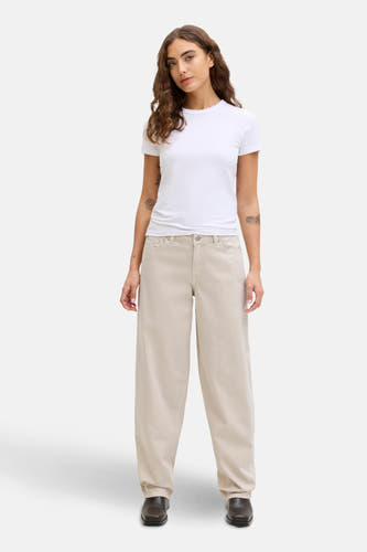 Ecru jeans met wijde pijpen van JJXX, gedragen met een wit T-shirt en bruine schoenen.